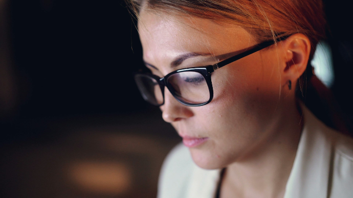 Femme portant des lunettes devant un écran